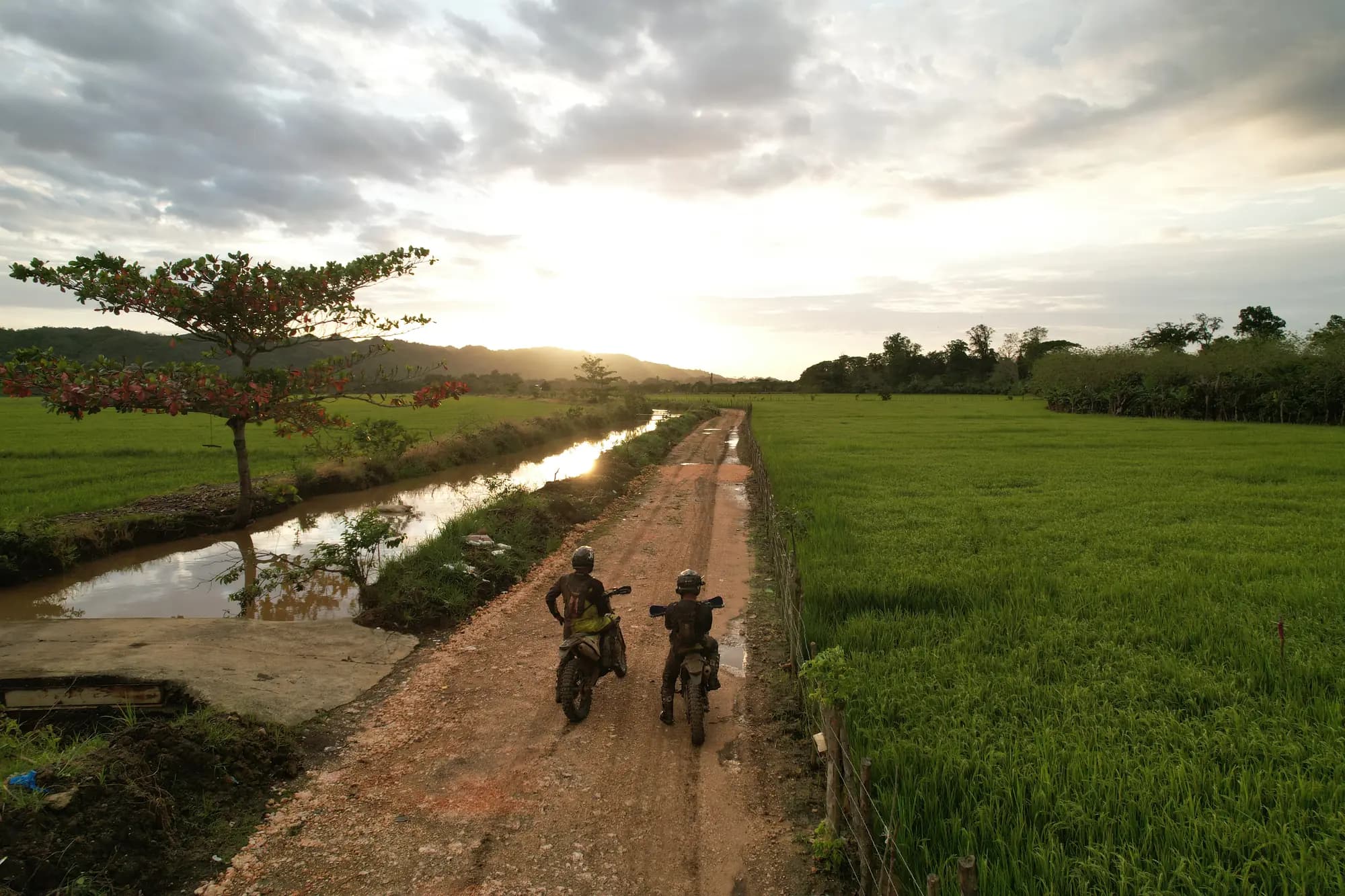Aerial view of riders on a dirt road at sunset