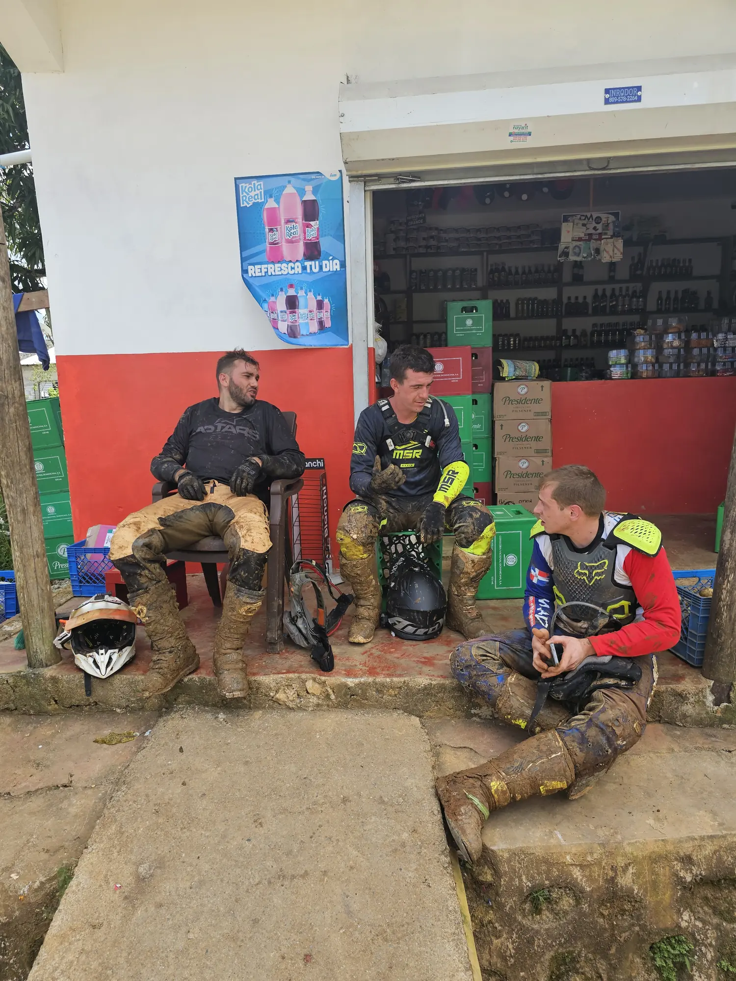 Riders taking a break at a village colmado