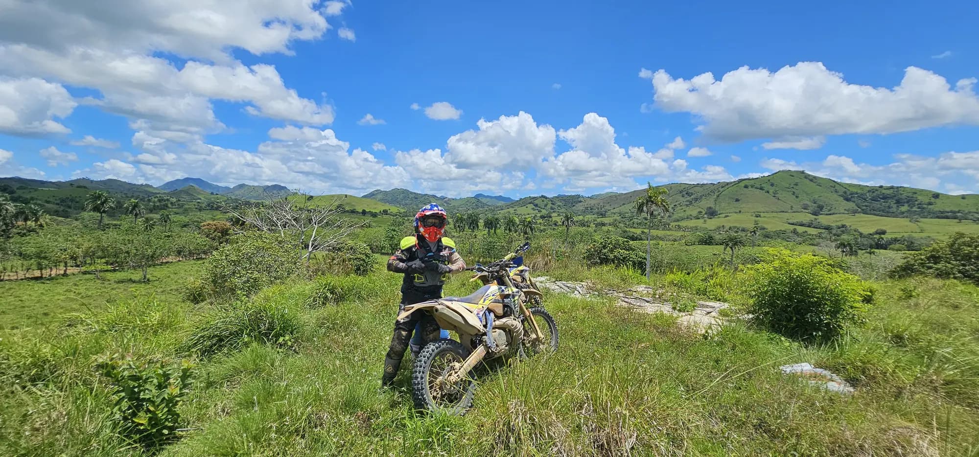 Rider crossing a grassy field below the mountains