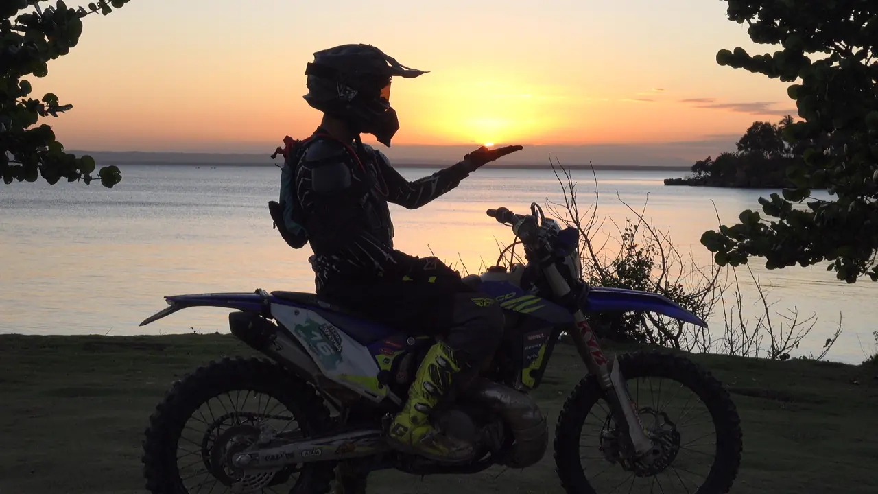 Rider silhouetted at sunset over the bay
